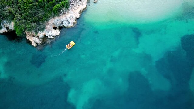 Aerial View of a Tropical Coastline and a Pedal Boat in Turquoise Waters