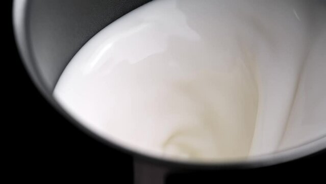 milk Heating and rotating in the milk frother for the homemade coffee, slow motion