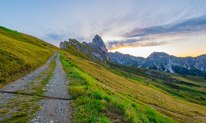 Golden sunrise at Seceda, Dolomites, Italy, illuminating the rugged landscape, casting a warm glow on the iconic peaks, and creating a serene morning spectacle.