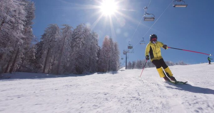 Front view pf professional skier skiing on slopes on a sunny winter day. Recorded at 120 fps on cinema camera. Ski run 04 clip 5 of 6.