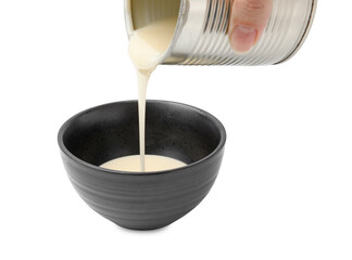 Woman pouring condensed milk from tin can into bowl isolated on white, closeup