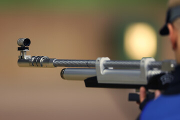 Bullet shooting from an air rifle. A man shoots at a shooting range.