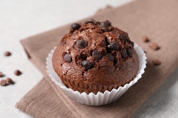 Tasty chocolate muffin on grey table, closeup