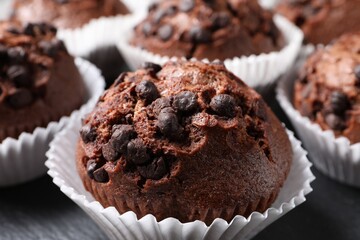Tasty chocolate muffins on black table, closeup
