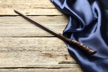 Old magic wand and fabric on wooden table