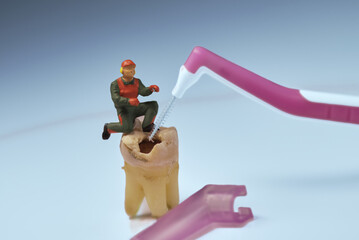 Recreation with miniature figures and a real tooth, worker and tools to clean the tooth that has a...