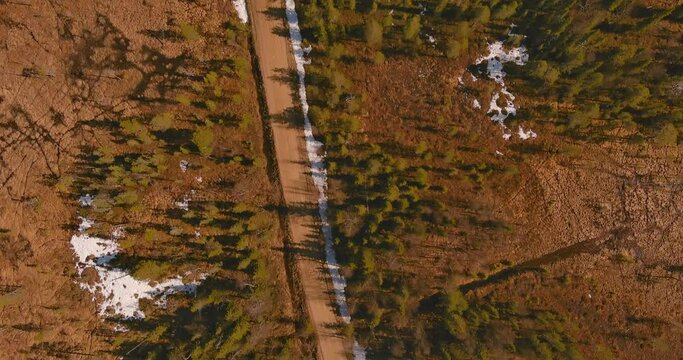 Aerial landscape view of gravel road in forest in spring, Sodankylä, Lapland, Finland.