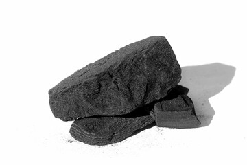 Pieces of black charcoal lie on a white background.