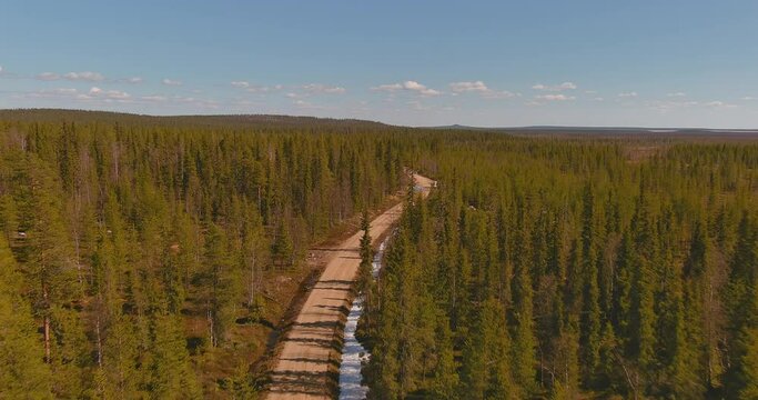 Aerial landscape view of gravel road in forest in spring, Sodankylä, Lapland, Finland.