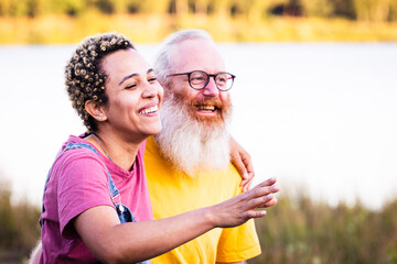 The photograph shows a serene moment between two people by a tranquil lakeside setting. A woman of...