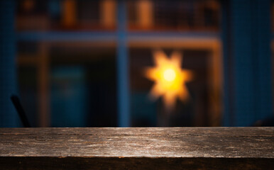 Layout. Empty dark wooden table in front of abstract blurred restaurant bokeh windows background....
