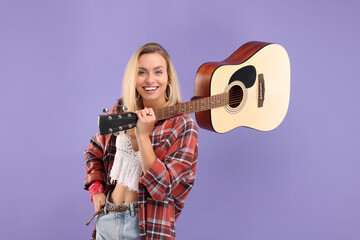 Happy hippie woman with guitar on purple background