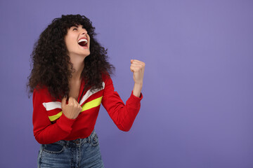 Happy sports fan celebrating on violet background, space for text