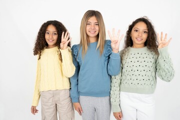 multi racial group of girl friends showing and pointing up with fingers number four while smiling confident and happy.