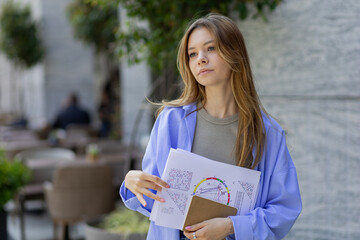 A numerologist girl with a numerological analysis and a phone in her hands. future by date of...