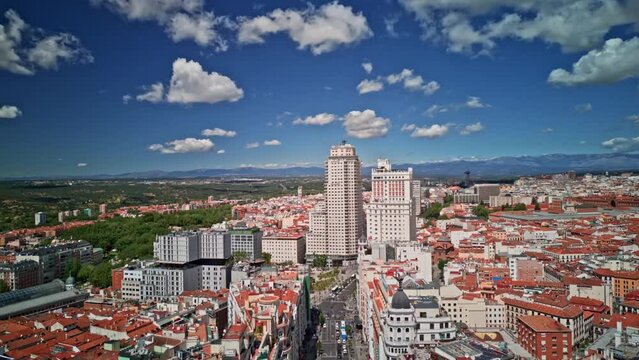 Establishing aerial view of Madrid Gran Via buildings architecture, cars driving and Torre de Madrid on a beautiful sunny day. Aerial Hyperlapse Time Lapse of Madrid tourist attraction