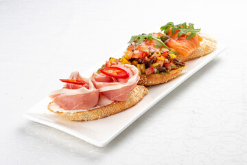 Bruschetta set, with salmon, prosciutto and vegetable salsa. Isolated image