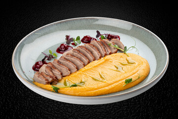 Duck breast, with pumpkin puree, cherry sauce and peanuts. Isolated image