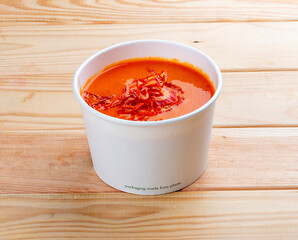Tomato soup. Healthy food. Takeaway food. On a wooden background.