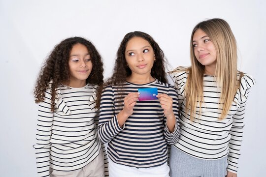 Photo of cheerful multi racial group of girl friends hold debit card look empty space