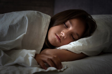 girl sleeping blanket on her bed during the night. face of a sleeping child in close-up