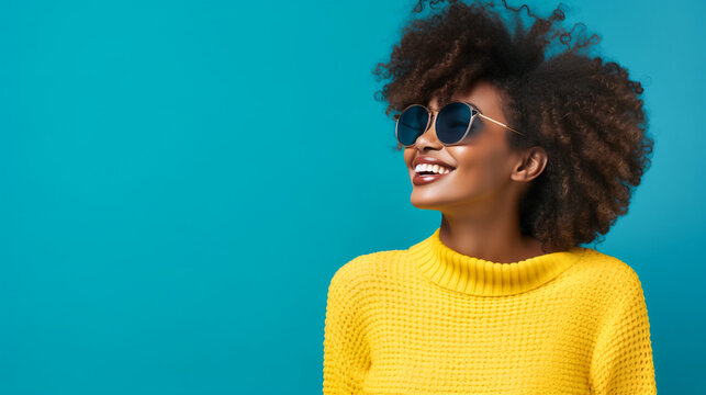 Beautiful Young Smiling Black Woman In Yellow Sweater Sunglasses On Blue Wall Background. Student Model. Education Skin Care Mental Health Concept