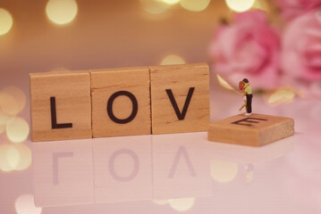 Recreation of a kissing straw, miniature figures in scale ho, along with the word love in wooden pieces