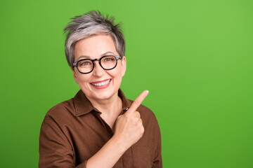Photo of toothy beaming woman with short hairdo wear brown shirt indicating at discount empty space...