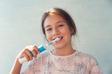 Teenage girl brushing teeth in bathroom at home. Dental care, hygiene and healthy lifestyle...
