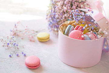 sweet colorful macaroons and cute colorful flowers on a delicate light background. Atmosphere of celebration and romance