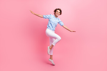 Full body photo of overjoyed gorgeous lady jumping arms wings flying isolated on pink color...
