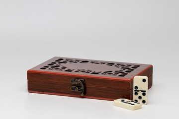 Wooden box with dominoes on white background