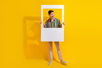 Full body portrait of man watching list of invited people for his birthday in paper frame photozone...