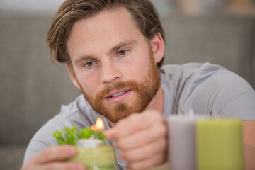 Fototapeta premium close-up young handsome man light up candle