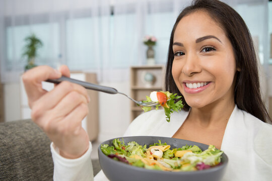 beautiful fit woman eating healthy salad after fitness workout