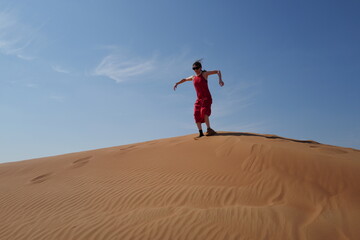 Woman in red dress on sand dunes