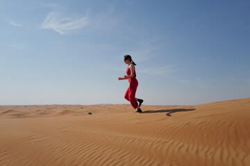 Woman in red dress on sand dunes 