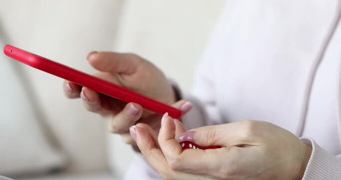 A woman uses a smartphone and sorts out game dice, close-up hands. Online casino betting, gambling addiction