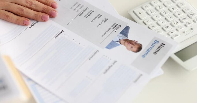 A woman's hand puts an approved seal on a resume, close-up. Candidate selection, recruitment, hiring