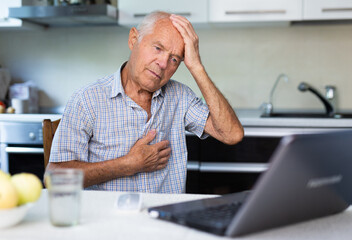 Elderly man describing symptoms to doctor during online consultation