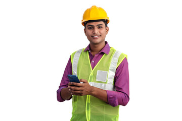 Indian male architect wearing yellow helmet and safety jacket posing with smartphone in studio.