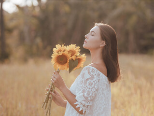 Close up portrait of attractive Caucasian woman holding sunflowers. Nature and outdoor concept. Summer time. Beautiful face profile. Closed eyes.