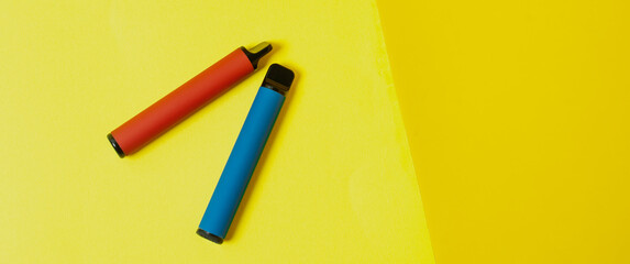Layout of colorful disposable electronic cigarettes on a multicolored background. The concept of modern smoking, vaping and nicotine. - obrazy, fototapety, plakaty