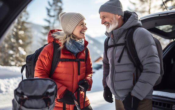 Happy senior couple wearing a backpack ready for snowboarding, outdoor winter sports