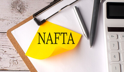 NAFTA word on yellow sticky with calculator, pen and clipboard - obrazy, fototapety, plakaty
