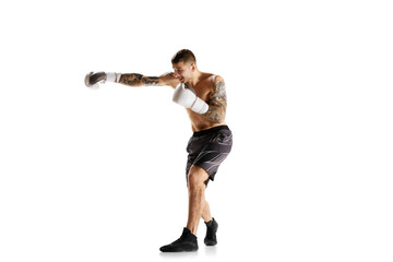 Full-length of shirtless young man with muscular strong body, boxer in motion, training isolated...