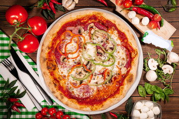 Pizza with quattro staggioni, mozzarella and tomato sauce. Pizza wooden table