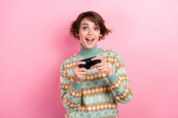 Portrait of girl brown bob hair addicted gaming free time spending holding wireless playstation joystick isolated on pink color background