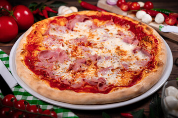 Pizza with prosciutto parma ham on wooden background top view. Italian cuisine
