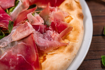 White pizza with prosciutto crudo, arugula and parmesan